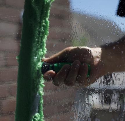 Ein Fensterputzer beim Einwaschen eines Fensters in Krefeld