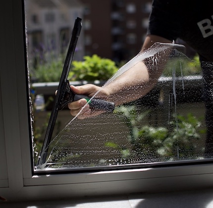 Ein Fensterputzer beim Abziehen eines frisch gewaschenen Fenster in Krefeld
