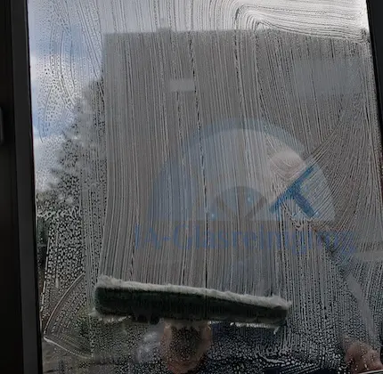 Unser Fensterputzer wäscht ein Fenster ein